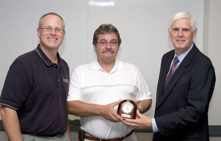 CAN DO President Kevin O'Donnell, right, and John Spevak, chairman of the board of directors, left, present Sweeney with a clock to mark his 10-year anniversary.