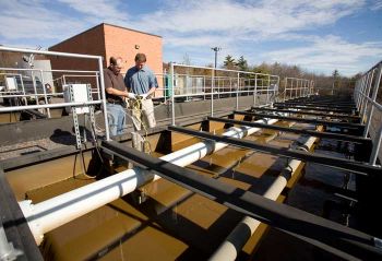 Adam Hoover, right, CAN DO assistant director of operations, and Keith Corsin, left, of Environmental Engineering and Management Associates, Inc., review oxygen levels during one step of the treatment process.